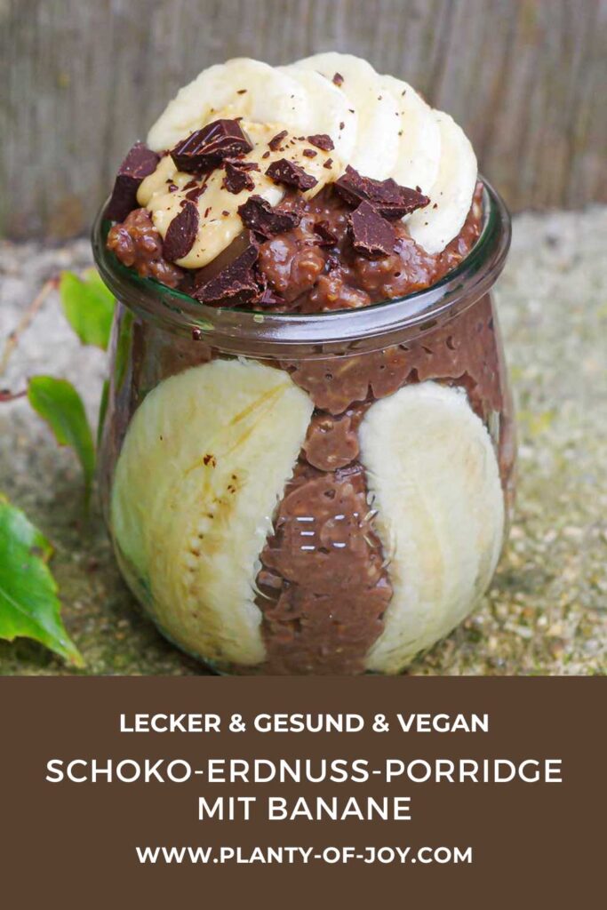 Cremiger Schoko-Erdnuss-Porridge mit Banane in einem kleinen Weckglas getoppt mit gehackter Schokolade, Erdnussmus und klein geschnittener Banane. Der untere Teil des Bildes ist dunkelbraun mit weißem Text. Der Text lautet lecker & gesund & vegan, Schoko-Erdnuss-Porridge mit Banane und die Domain der Website Planty of Joy.
