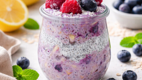 Cremiges Heidelbeer-Chia-Müsli im Glas, getoppt mit frischen Beeren und Haferflocken